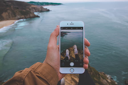 person holding iPhone showing his white sneakers thumbnail