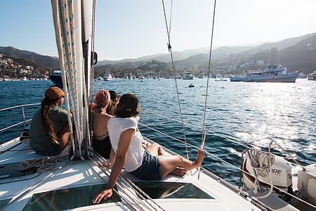 group of people sitting on top of sail boat watching ships thumbnail