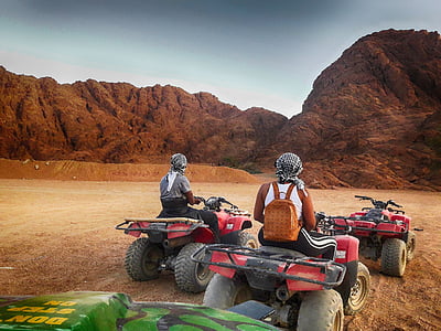 person riding on ATV near mountains thumbnail