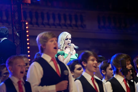 people singing on stage at night time thumbnail