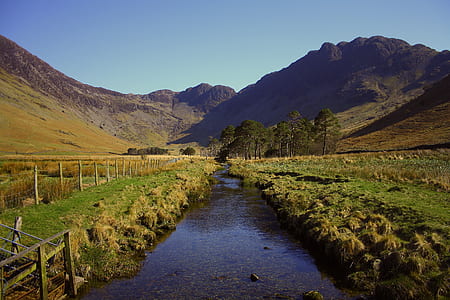 photo of river heading mountain surrounded by grass thumbnail
