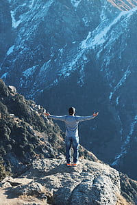man spreading his arms on top of mountain thumbnail