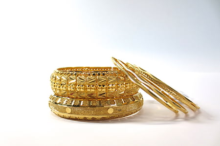 two gold-colored bangles beside three bangles thumbnail