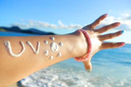 person in pink beaded bracelet and white cream on hand thumbnail