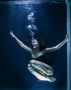 woman wearing black bodysuit diving on water thumbnail