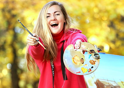 woman in red pullover hoodie holding palette with paint brush thumbnail