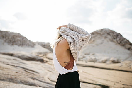 woman in white tank top covering her head with brown knit sweater photo taken during daytime thumbnail