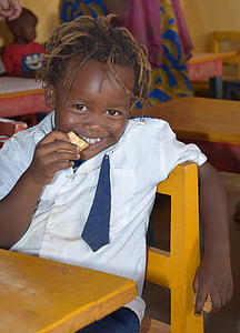 boy sitting on chair while eating biscuit thumbnail