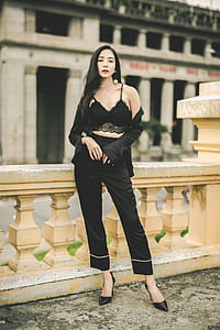 woman in black bralette and pants standing beside concrete railings thumbnail