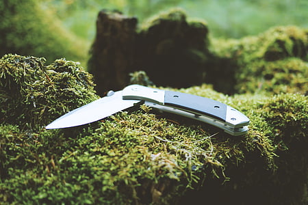 black and gray folding knife on green moss thumbnail