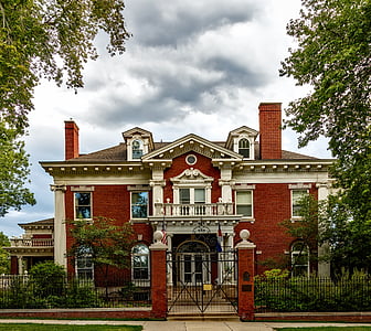 red and white 2-storey building with gate under cloudy sky thumbnail