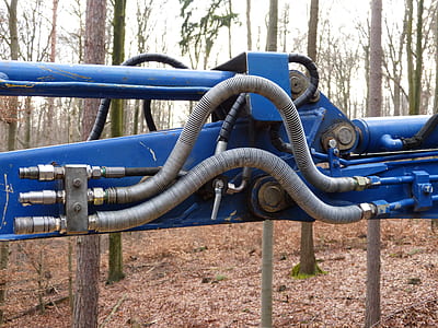 blue heavy equipment beside trees thumbnail