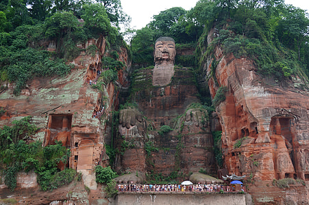 group of people in front of a profile of man carved on a mountain side during daytime thumbnail