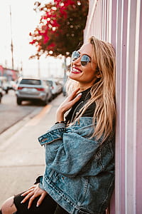 woman standing beside white and purple wall during daytime thumbnail