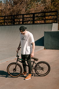 man wearing white shirt holding BMX bike thumbnail