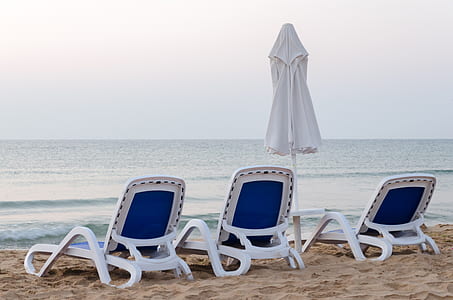 three outdoor loungers and one patio umbrella at beach side thumbnail