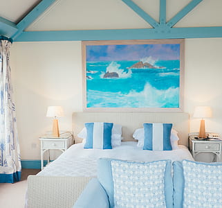 painting of sea waves hitting rocks above bed thumbnail