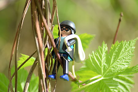 male toy character hanging on green leafed vine plant thumbnail