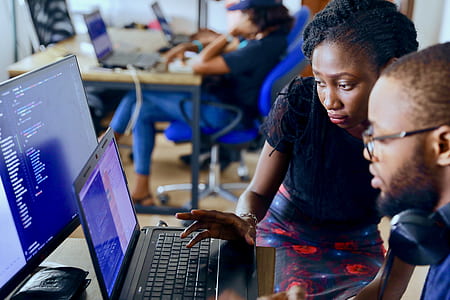 woman and man using laptop near sitting woman during daytime thumbnail