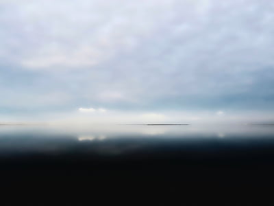 calm body of water under white cloudy skies at daytime thumbnail