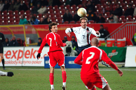 three men playing soccer on field thumbnail