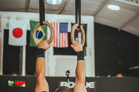 close-up photo of man grabbing gymnastic rings thumbnail