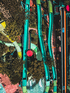 green and teal plastic pool slide aerial photography during daytime thumbnail