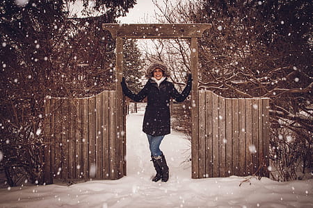 Woman in Black Coat Beside Fence during Snow thumbnail