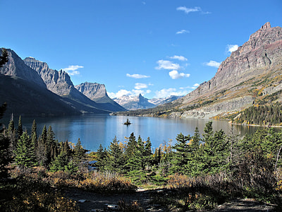 landscape photography of body of water surrounded by trees and mountain under blue sky at daytime thumbnail