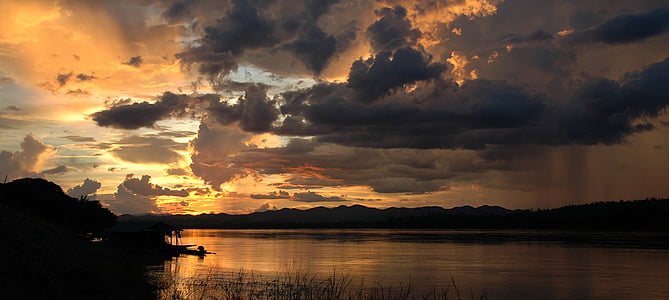 silhouette photo of body of water and mountain thumbnail