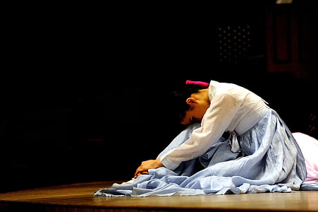 woman wearing white and purple long-sleeved dress lying on brown wooden surface thumbnail