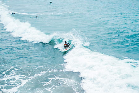 person surfing using white surfboard during daytime thumbnail