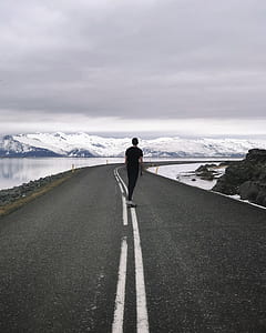architectural photography of man on road thumbnail