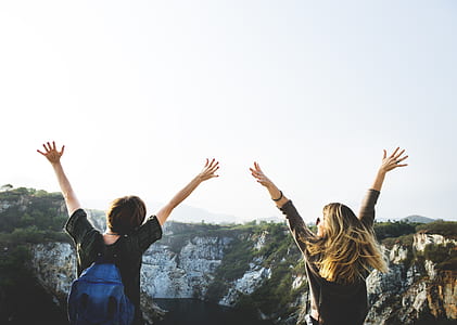 man and woman waving hands during daytime thumbnail
