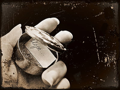 person holding round gray metal case thumbnail