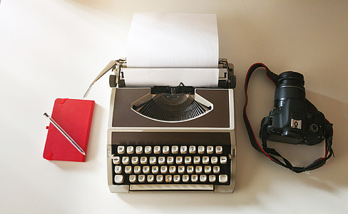 black DSLR camera; grey typewriter; red tablet computer flip case thumbnail