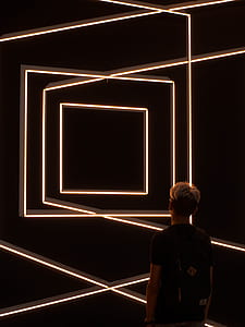man in black top wearing backpack in dark room lowlight photography thumbnail