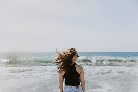 woman in front of sea waves at daytime thumbnail