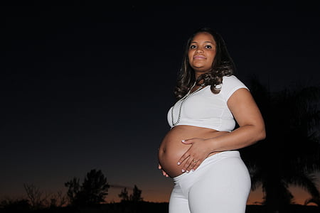 pregnant woman holding her tummy outdoors thumbnail