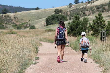 woman and boy walking on brown pathway outdoors thumbnail