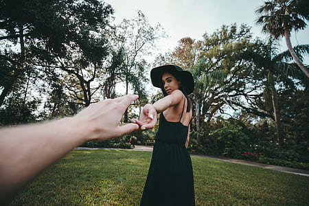 woman standing on green grass reaching left human hand thumbnail