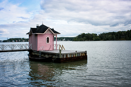 pink wooden house on body of water thumbnail