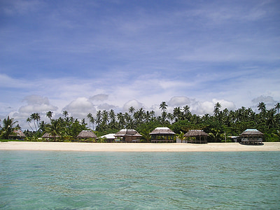 island near body of water under cloudy sky during daytime thumbnail