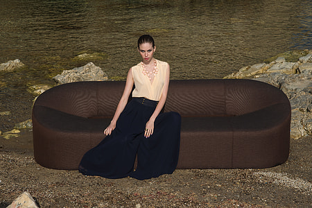 sitting woman on the sofa beside body of water thumbnail