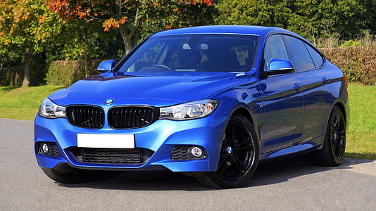 Blue Bmw Sedan Near Green Lawn Grass thumbnail