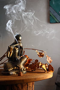 male sitting figurine on top brown table thumbnail