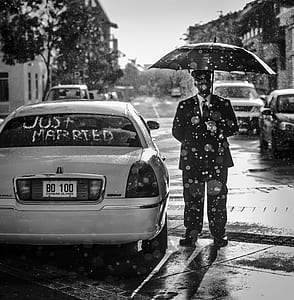 person holding umbrella standing beside car thumbnail