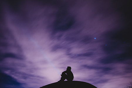 silhouette photography of person sitting on ground thumbnail