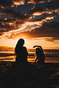 silhouette of woman and girl on beach thumbnail