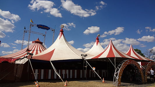 white and red carnival tents under cloudy sky during daytime thumbnail